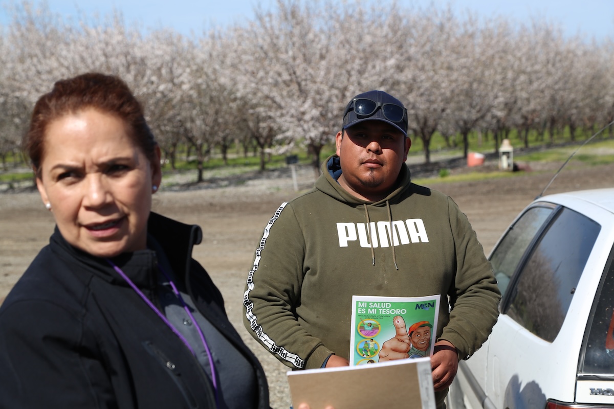 <div class="cs-caption-text-photo-credit">photo by Manuel Ortiz</div><div>As a promotora, Maria Soto connects migrant farm working communities in California’s rural north with newly available opportunities to gain healthcare through newly-expanded Medi-Cal. Here she speaks with Simon Vazquez, who leads a team of Glenn County farm workers.</div>